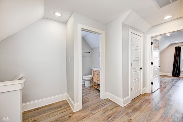 hallway featuring lofted ceiling and light wood-type flooring