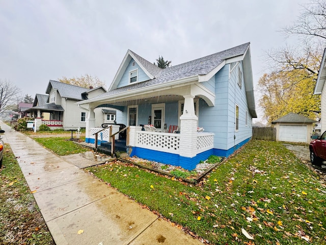 view of front facade featuring an outbuilding, a garage, a front yard, and covered porch