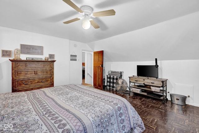 bedroom with dark parquet floors, ceiling fan, and vaulted ceiling