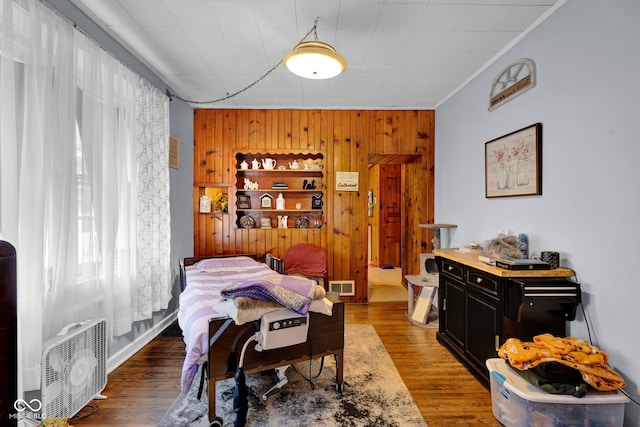 dining area with wooden walls, hardwood / wood-style flooring, and crown molding