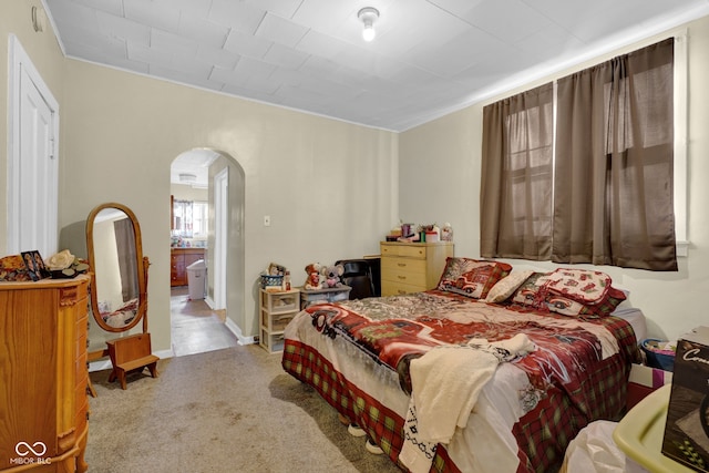 bedroom featuring light colored carpet and ornamental molding