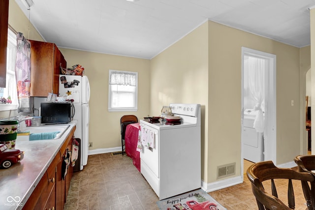 kitchen featuring white electric stove, washer / clothes dryer, and sink