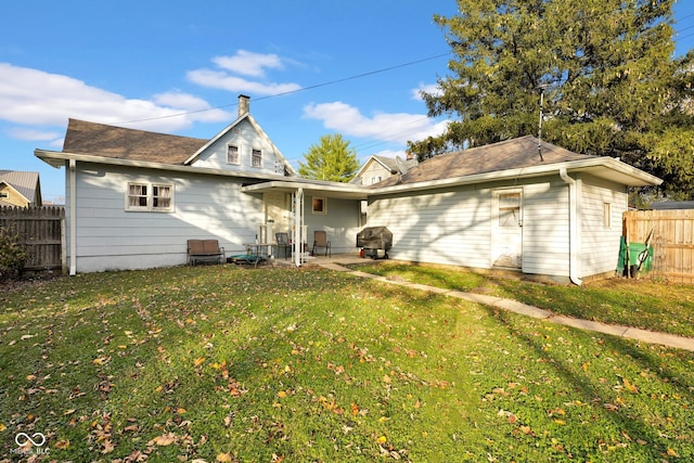 rear view of house featuring a patio and a yard