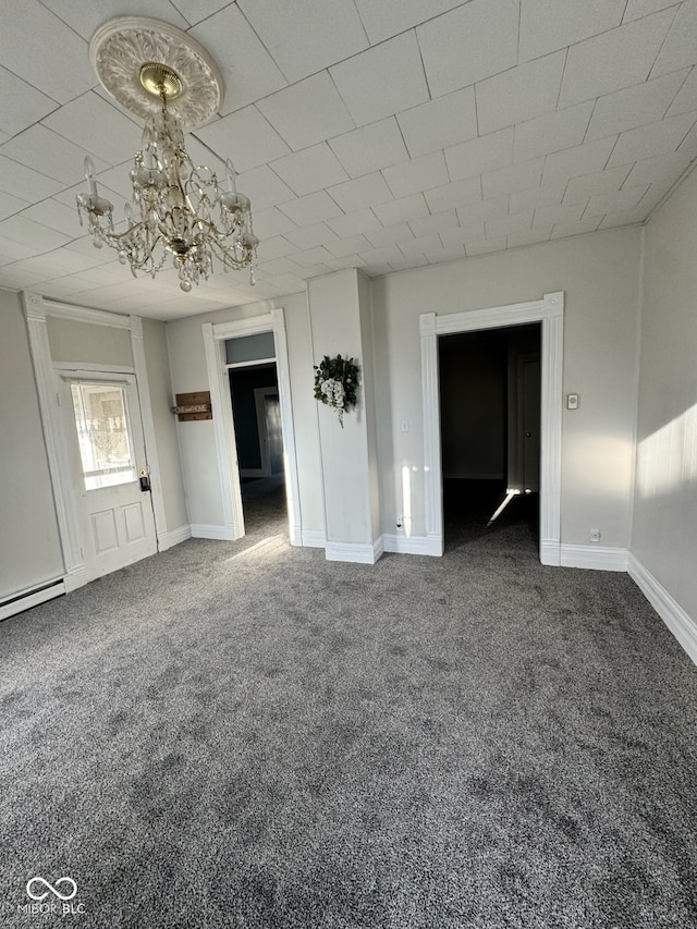 spare room with a chandelier and dark carpet