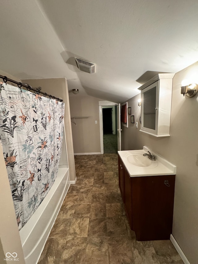 bathroom featuring vanity, shower / tub combo, and vaulted ceiling