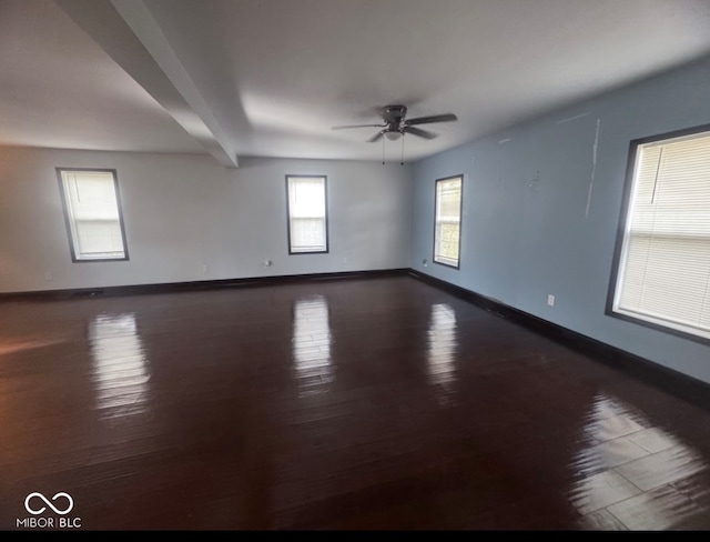 unfurnished room featuring beamed ceiling, ceiling fan, and dark wood-type flooring