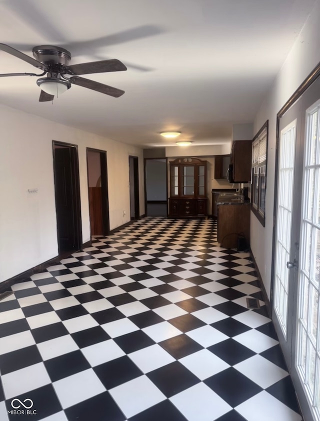 empty room with a wealth of natural light, french doors, and ceiling fan