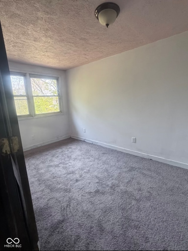 unfurnished room featuring carpet flooring and a textured ceiling