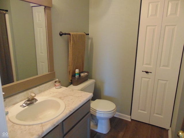 bathroom with vanity, hardwood / wood-style flooring, and toilet