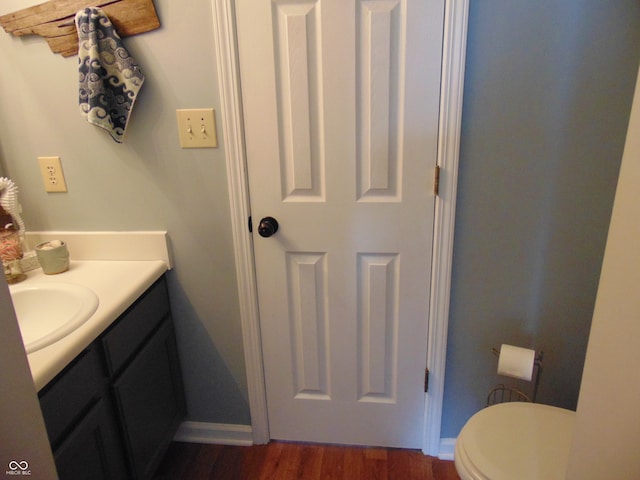 bathroom featuring wood-type flooring, vanity, and toilet