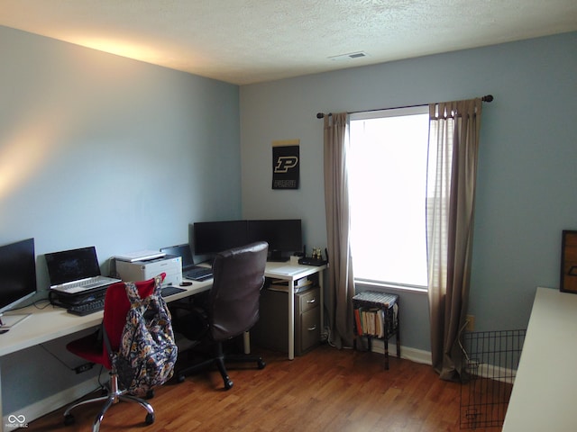 home office featuring hardwood / wood-style flooring and a textured ceiling