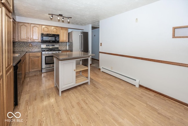 kitchen featuring black appliances, backsplash, light wood-type flooring, baseboard heating, and a center island