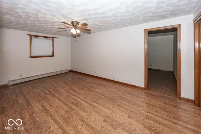 spare room featuring hardwood / wood-style floors, ceiling fan, a textured ceiling, and a baseboard heating unit