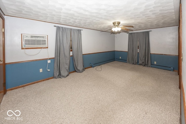 basement featuring a wall mounted AC, a baseboard heating unit, a textured ceiling, and ceiling fan