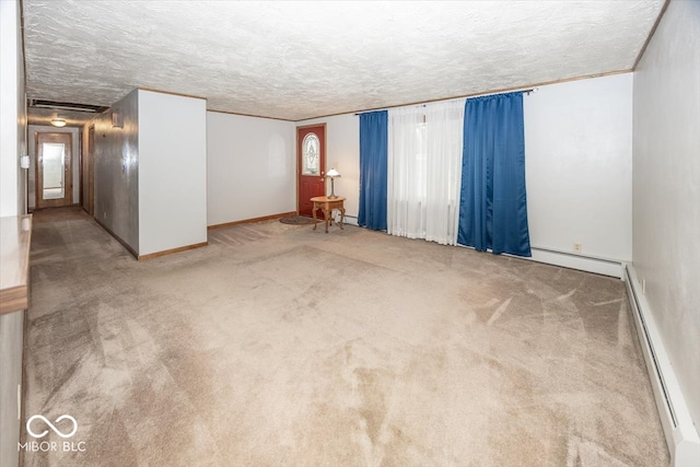 spare room featuring a textured ceiling, a baseboard heating unit, and carpet