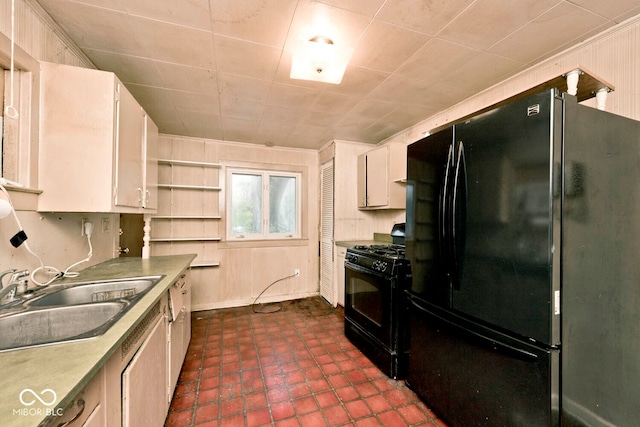 kitchen with white cabinets, wooden walls, sink, and black appliances