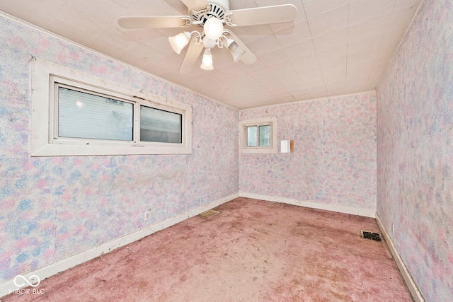 unfurnished room with ornamental molding, carpet, and ceiling fan