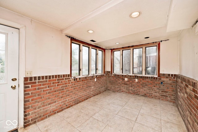 tiled empty room with brick wall