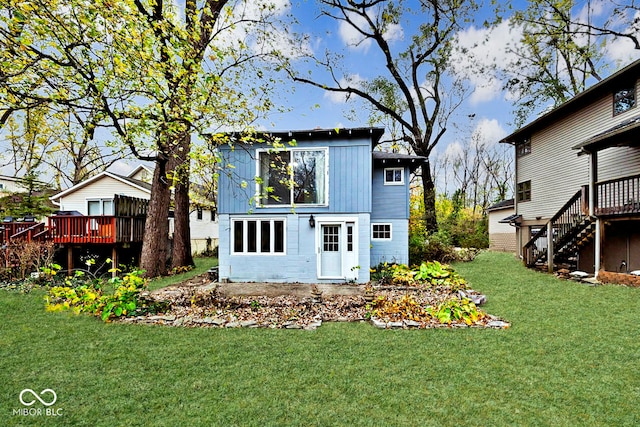 rear view of property featuring a wooden deck and a yard