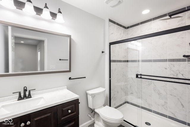 bathroom with vanity, toilet, and a shower with shower door