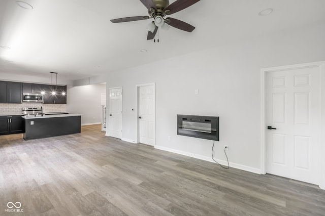 unfurnished living room with hardwood / wood-style flooring, ceiling fan, and heating unit