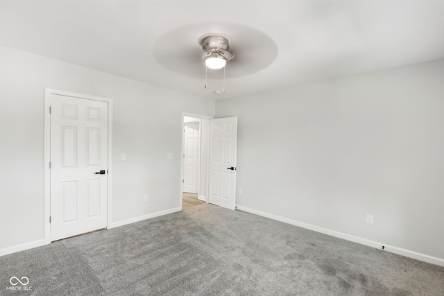 carpeted spare room featuring ceiling fan