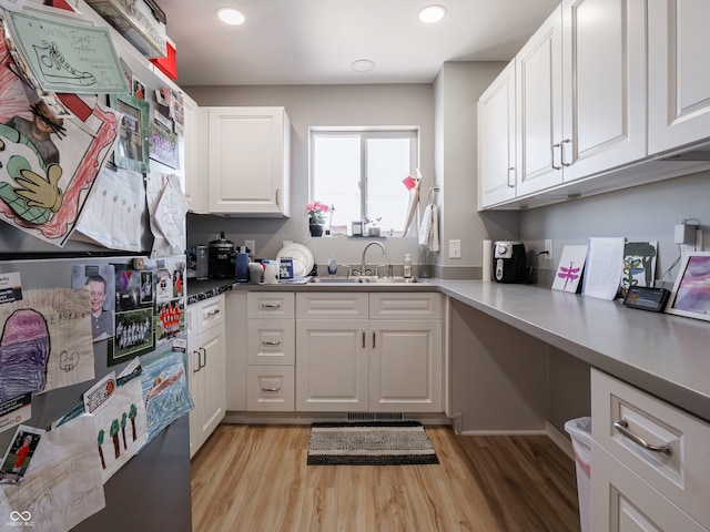 kitchen featuring light hardwood / wood-style flooring, sink, and white cabinets