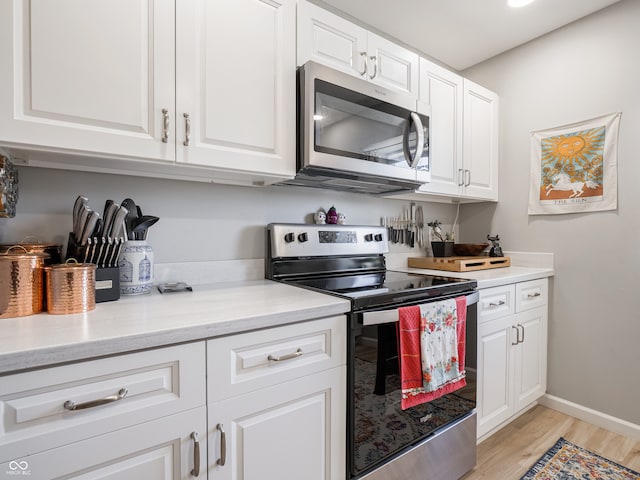 kitchen featuring white cabinetry, appliances with stainless steel finishes, and light hardwood / wood-style flooring