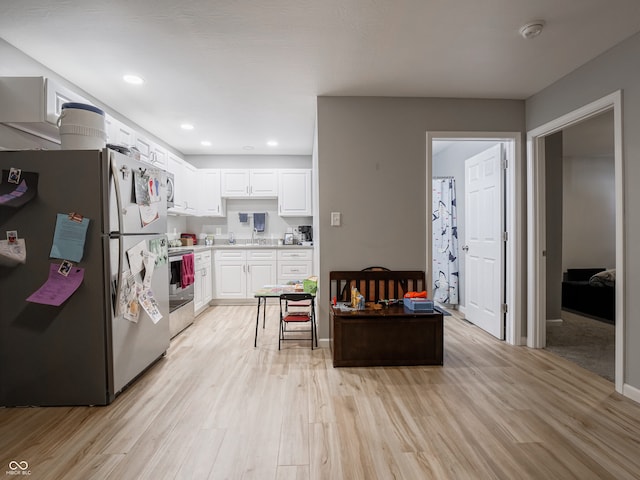 kitchen featuring stainless steel appliances, light hardwood / wood-style floors, white cabinetry, and sink