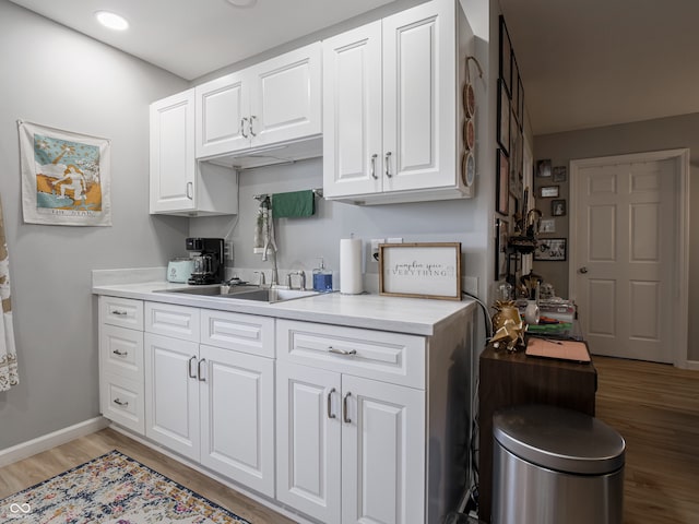 kitchen featuring white cabinets, hardwood / wood-style floors, and sink