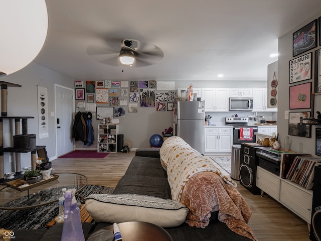 living room with light hardwood / wood-style flooring and ceiling fan