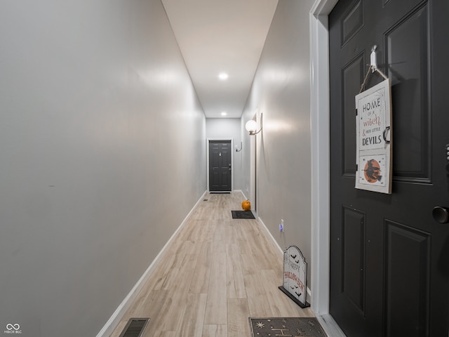 hallway with light hardwood / wood-style floors