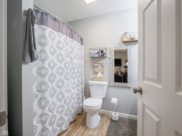 bathroom featuring toilet, hardwood / wood-style floors, and walk in shower