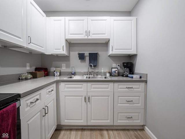 122 N Washington St, Frankton, IN 46044 - kitchen with a sink, white cabinetry, light wood-style floors, light countertops, and electric range