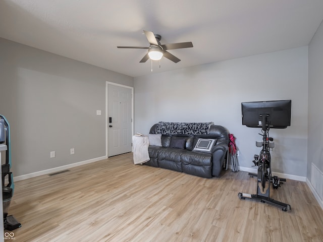 exercise area featuring ceiling fan and light hardwood / wood-style flooring