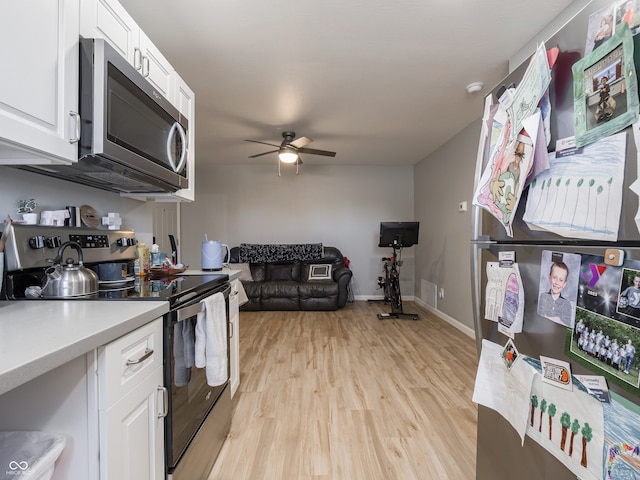 kitchen with light wood-type flooring, white cabinets, ceiling fan, and stainless steel appliances