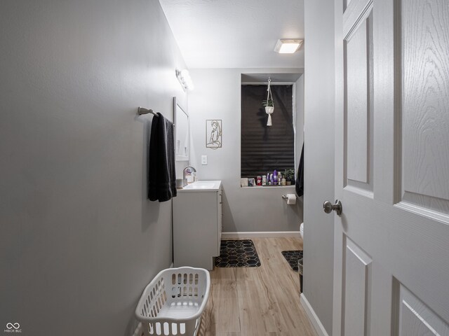 122 N Washington St, Frankton, IN 46044 - half bathroom featuring wood finished floors, vanity, toilet, and baseboards