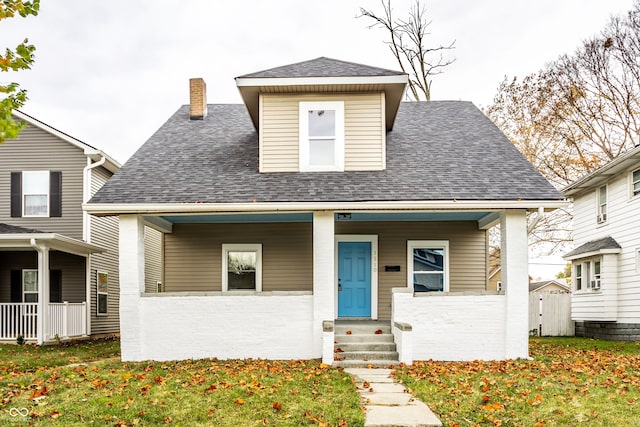 view of front of home with a front lawn, a shed, and covered porch