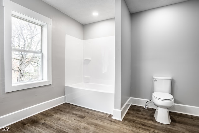 bathroom with hardwood / wood-style flooring, a healthy amount of sunlight, and toilet