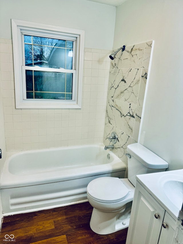 full bathroom with hardwood / wood-style floors, vanity, toilet, and tiled shower / bath