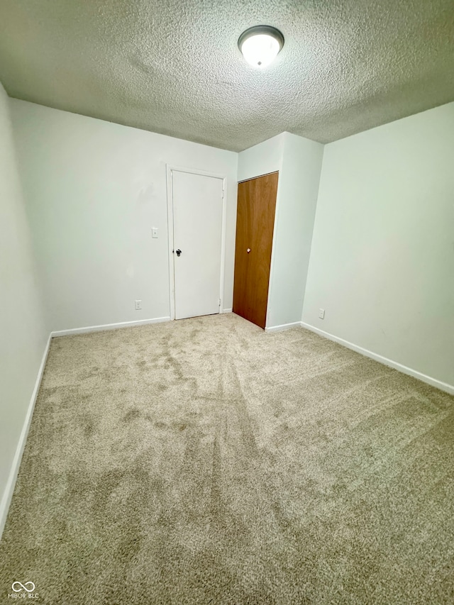 carpeted empty room with a textured ceiling