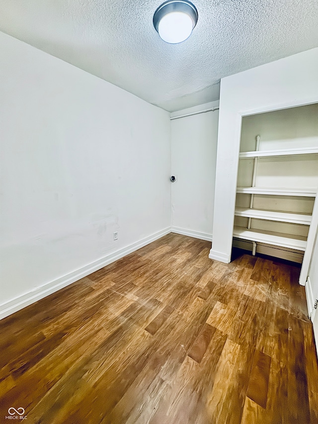 unfurnished bedroom featuring hardwood / wood-style floors, a textured ceiling, and a closet