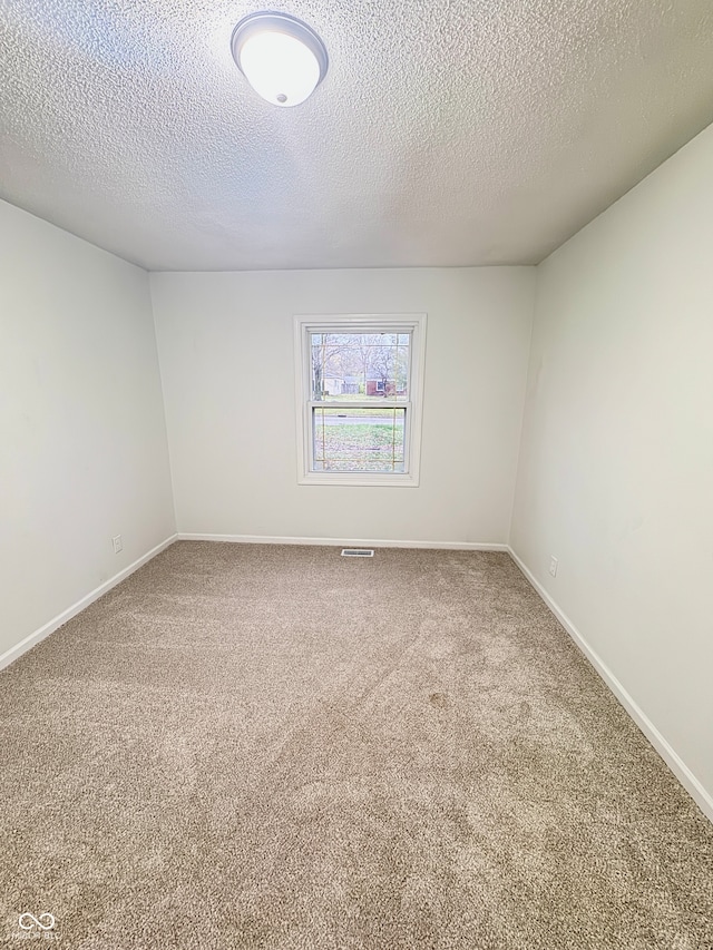 empty room with carpet and a textured ceiling