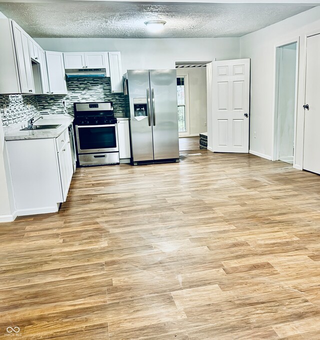 kitchen featuring white cabinetry, sink, light wood-type flooring, and appliances with stainless steel finishes