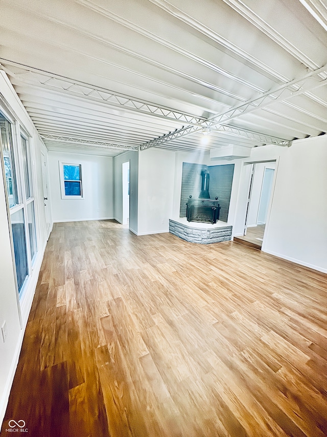 unfurnished living room with a wood stove and hardwood / wood-style flooring