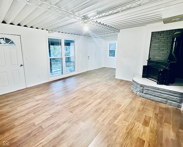 unfurnished living room featuring a wood stove and hardwood / wood-style floors