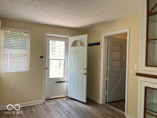 doorway to outside featuring wood-type flooring and a textured ceiling