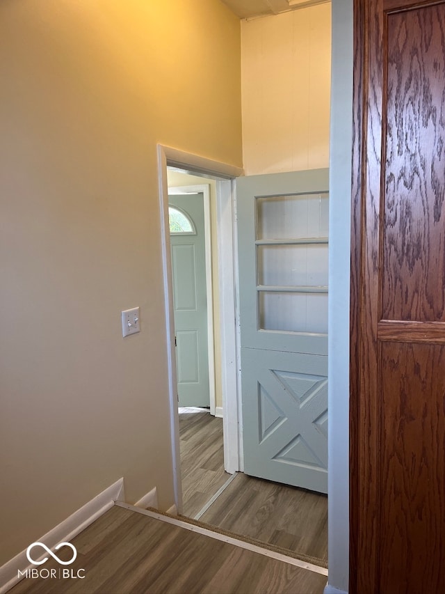 corridor with built in shelves and hardwood / wood-style floors