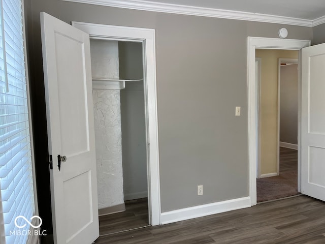 unfurnished bedroom with ornamental molding, dark hardwood / wood-style flooring, and a closet