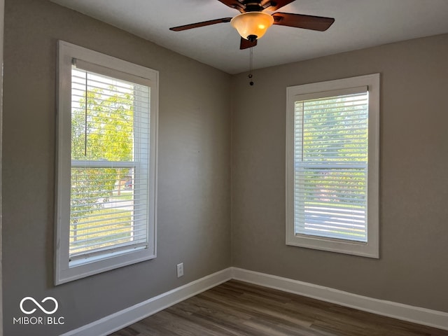 empty room featuring dark hardwood / wood-style flooring, a healthy amount of sunlight, and ceiling fan